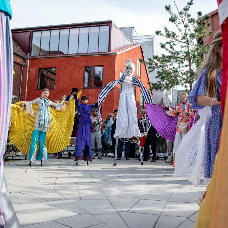 Photo of the small square on Århusgade featuring a parade and people in costume